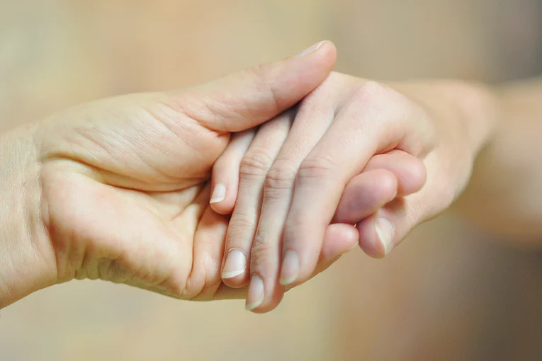 Eine Hand hält eine andere.